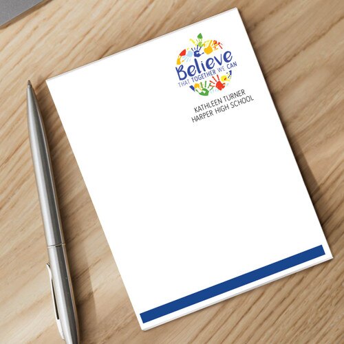 personalized believe apple notepad and silver pen sitting on a desk