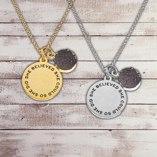 gold and silver necklaces with "She Believed She Could So She Did” message