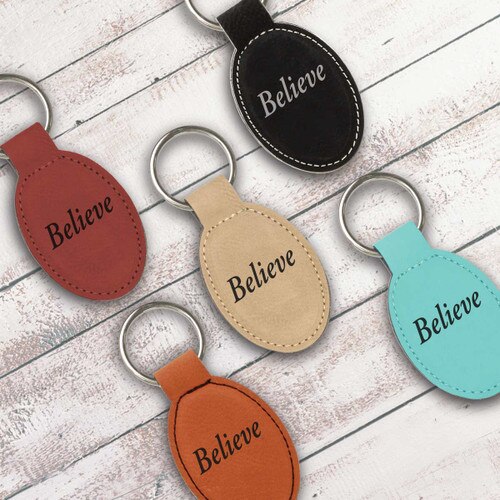 multiple colors of oval keychains with believe message
