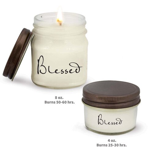 two white candle in glass jar with blessed message